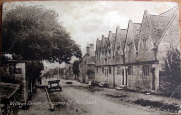 Postcrd of the main street showing the Alms Houses
